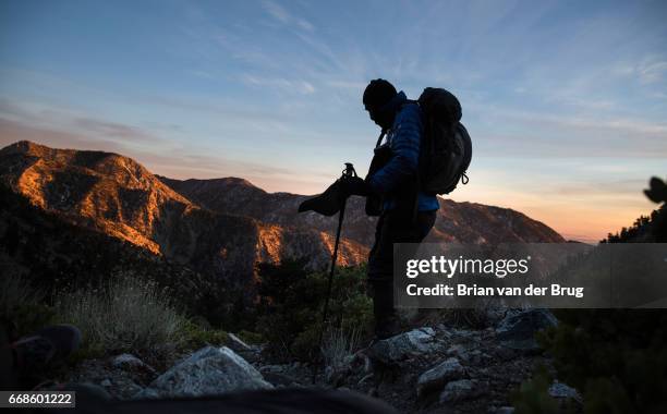 Sam Kim takes in the sunset light bathing the shoulders of the San Gabriel Mountains on hike down from the Mt. Baldy summit, a trek he has made more...