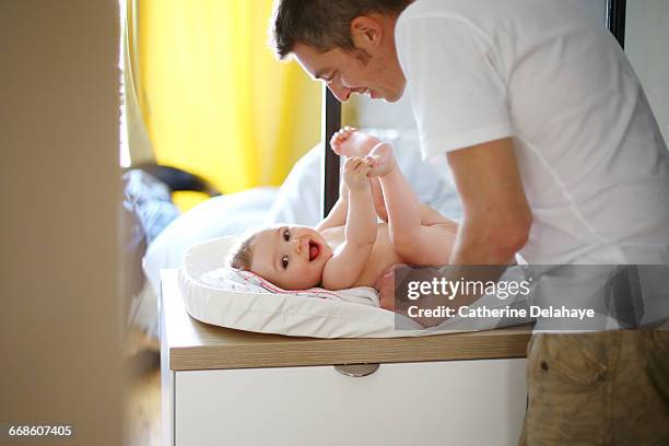 a dad with his baby on the changing table - changing nappy stock pictures, royalty-free photos & images