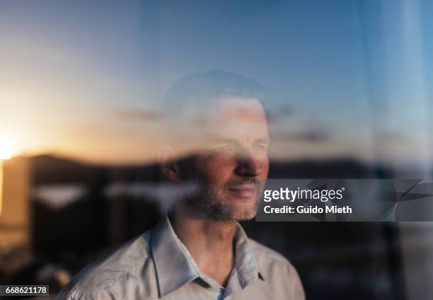 businessman looking out of a window. - reflection photos et images de collection