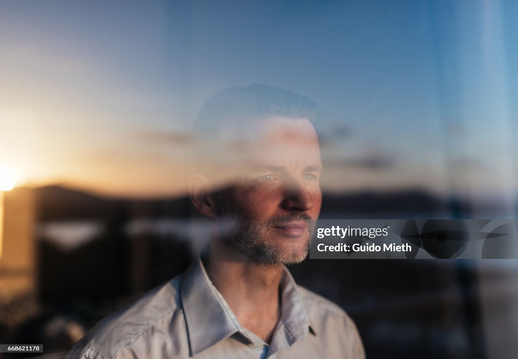 Businessman looking out of a window.