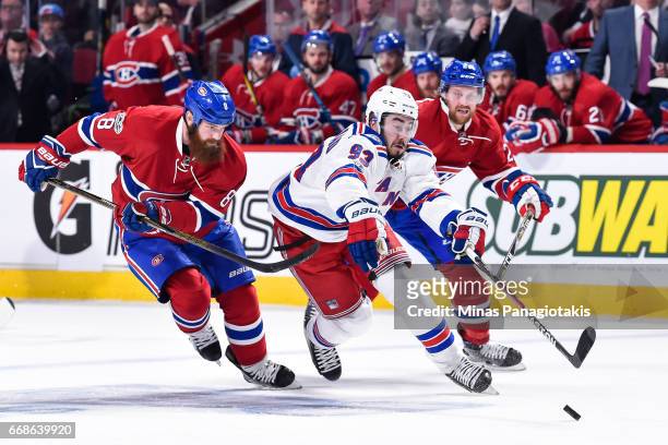 Mika Zibanejad of the New York Rangers skates the puck against Jordie Benn of the Montreal Canadiens in Game Two of the Eastern Conference First...
