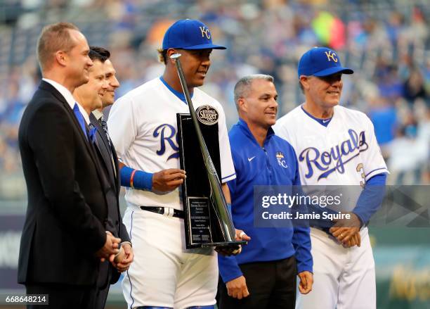 Salvador Perez of the Kansas City Royals is presented with the Louisville Slugger Silver Slugger Award as General Manager Dayton Moore and Manager...