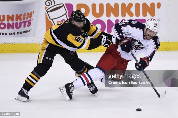 Pittsburgh Penguins Defenseman Trevor Daley checks Columbus Blue Jackets left wing Scott Hartnell as he moves the puck during the third period. The...