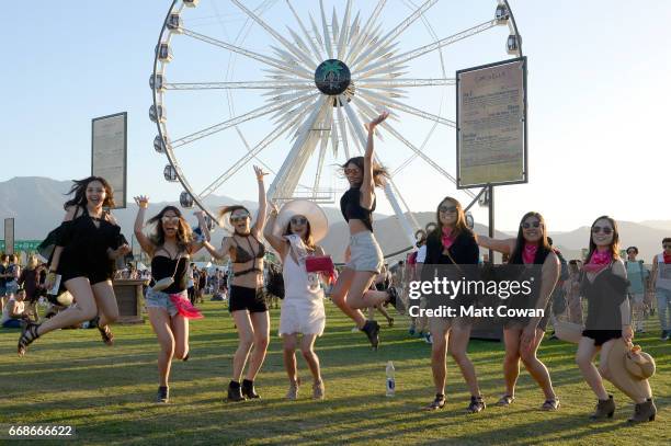 Festivalgoers pose in front of the ferris wheel during day 1 of the Coachella Valley Music And Arts Festival at the Empire Polo Club on April 14,...