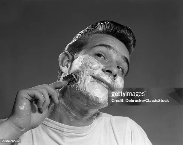 1950s YOUNG MAN SHAVING WITH SAFETY RAZOR