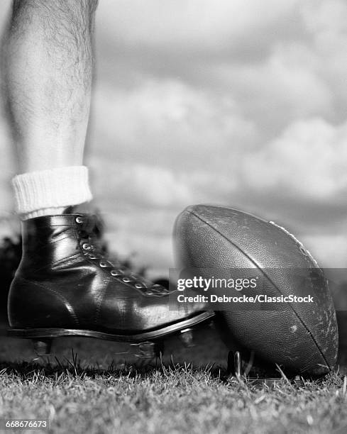 1950s 1960s FOOTBALL PLAYER SHOWN BELOW KNEE KICKING FOOTBALL