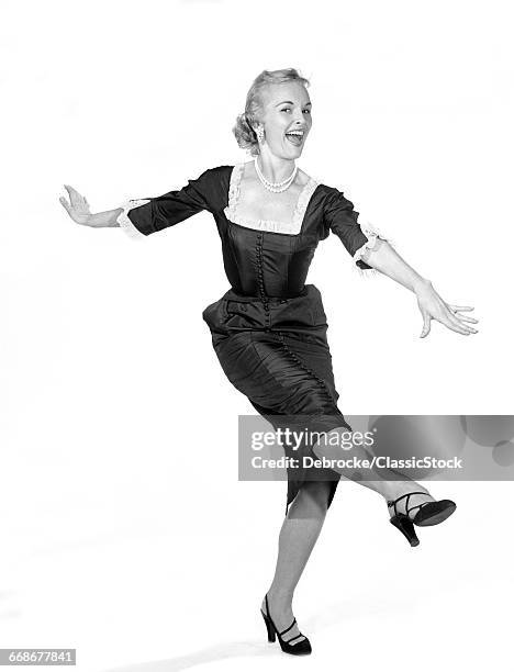 1950s LAUGHING HAPPY EXCITED WOMAN DANCING KICKING LEG LOOKING AT CAMERA