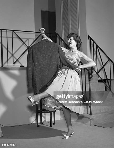 1960s WOMAN IN COCKTAIL DRESS DANCING WITH MANS EMPTY JACKET