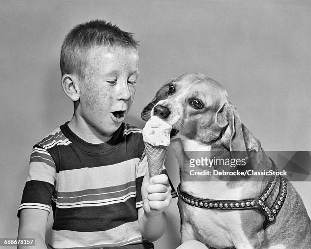 1950s FRECKLE FACE BOY SHARING ICE CREAM CONE WITH PET DOG