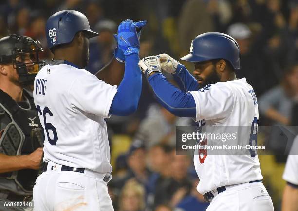 Andrew Toles of the Los Angeles Dodgers is greeted by Yasiel Puig of the Los Angeles Dodgers after a two run home run in the eighth inning of the...