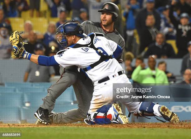 Chris Iannetta of the Arizona Diamondbacks is called safe as he beats the tag by Yasmani Grandal of the Los Angeles Dodgers on a single by Chris...
