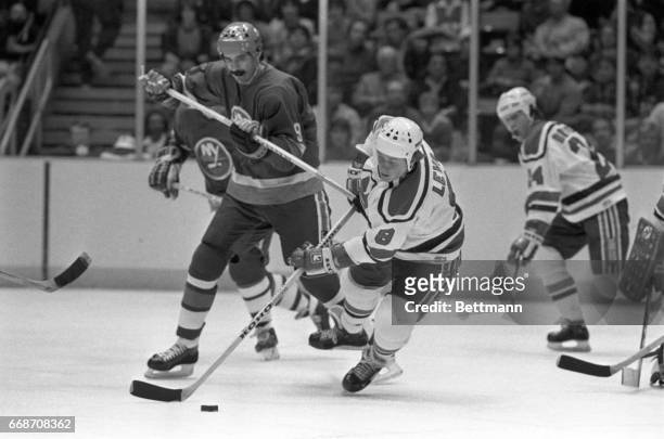 New York Islanders’ Clark Gillies uses his stick to prevent New Jersey Devils’ Tapio Levo from getting control of the puck during the third period of...
