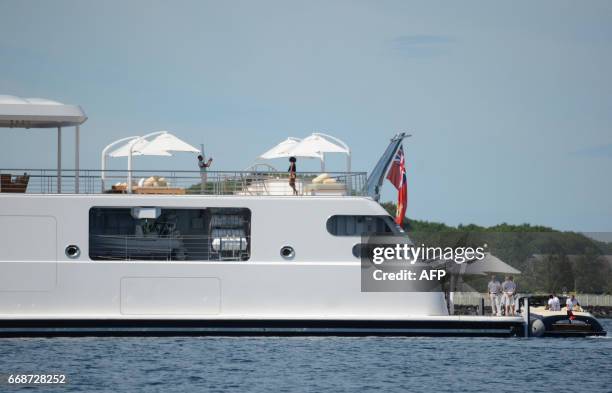 Former US President Obama take a holiday snap of his wife Michelle, as she poses on the top deck of the 138 meter Rising Sun yacht where the couple...