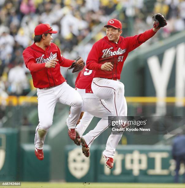 Seiya Suzuki celebrates with fellow Hiroshima Carp outfielders after a 7-1 win over the Hanshin Tigers at Koshien Stadium in Nishinomiya, Japan, on...