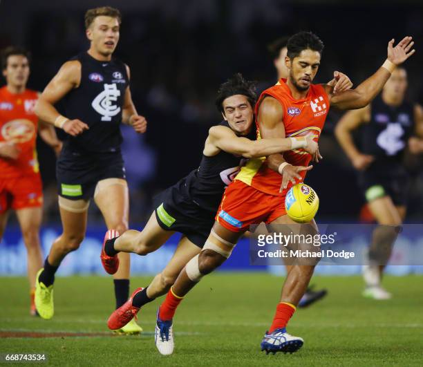 Zac Fisher of the Blues tackles Aaron Hall of the Suns during the round four AFL match between the Carlton Blues and the Gold Coast Suns at Etihad...