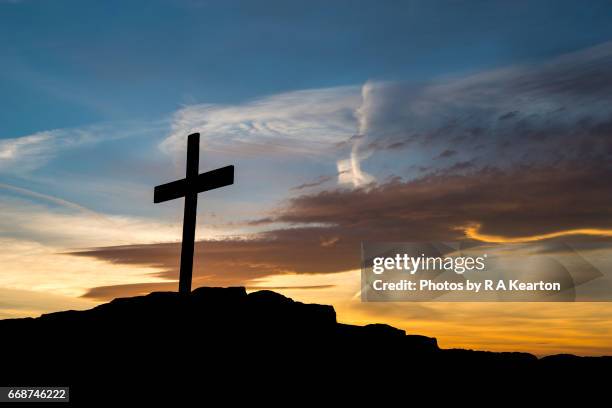 wooden cross on a hilltop at sunset - croix religieuse photos et images de collection