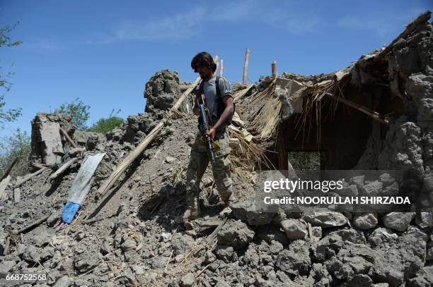 An Afghan soldier patrols near the site of a US bombing during an operation against Islamic State militants in the Achin district of Nangarhar...