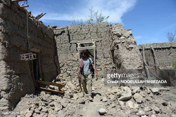 An Afghan soldier patrols near the site of a US bombing during an operation against Islamic State militants in the Achin district of Nangarhar...