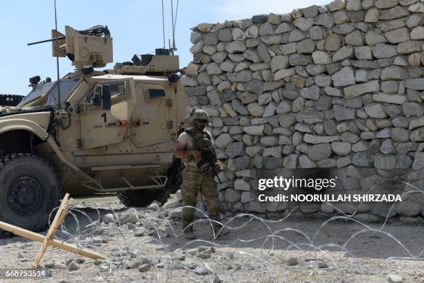 Soldier patrols near the site of a US bombing during an operation against Islamic State militants in the Achin district of Nangarhar province on...