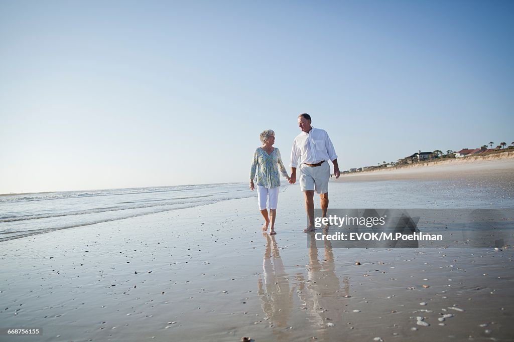 Senior couple with walking on beach holding hands