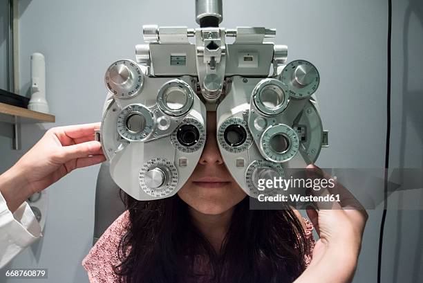 ophthalmologist adjusting an optometrist phoropter, ready for eye calibration of a patient - réfracteur photos et images de collection