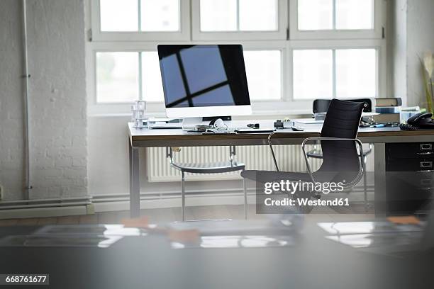 desk and chair in bright office - arbeitsplatz stock-fotos und bilder