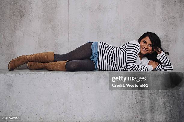 female indian laying on concrete wall - acostado de lado fotografías e imágenes de stock