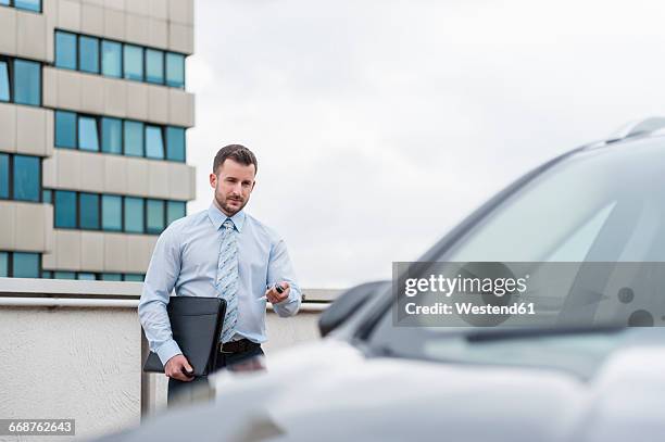 businessman opening car on parking lot - cars in parking lot stockfoto's en -beelden