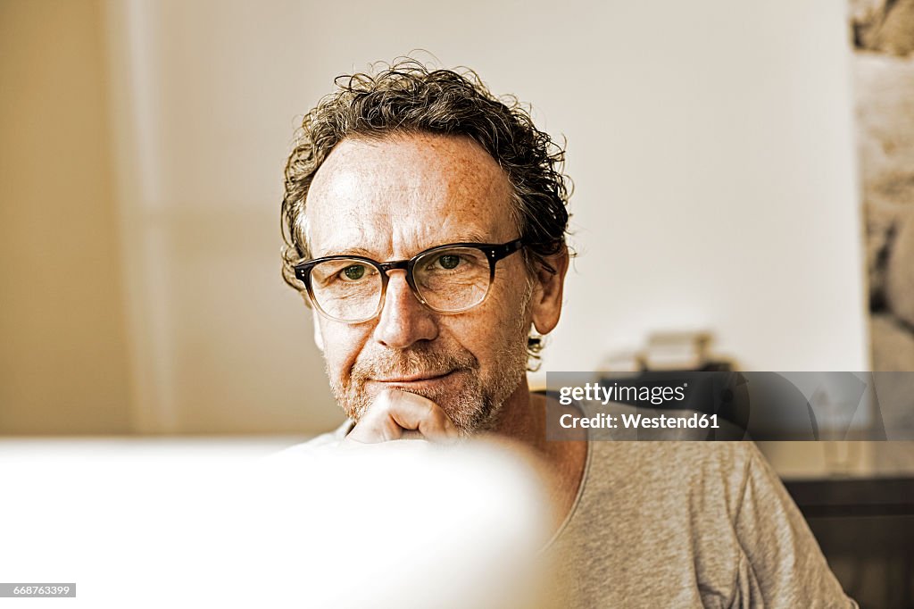 Portrait of pensive man looking at computer