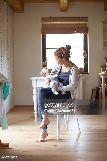 mother with baby boy at home - mum sitting down with baby stockfoto's en -beelden