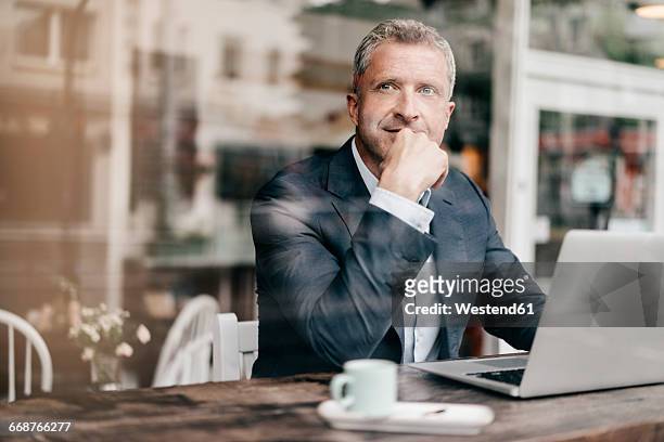 businessman sitting in cafe, working - businessman contemplation stock pictures, royalty-free photos & images