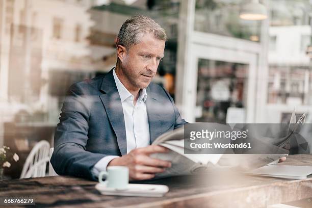 businessman in cafe reading newspaper - coffee and news paper foto e immagini stock