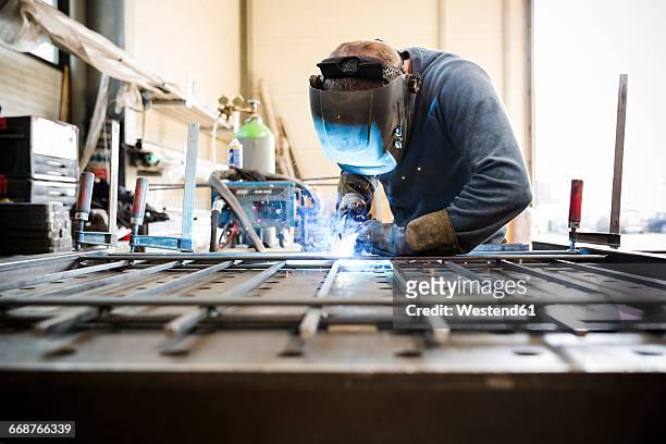 metal construction, welder welding railing - metallindustrie stock-fotos und bilder