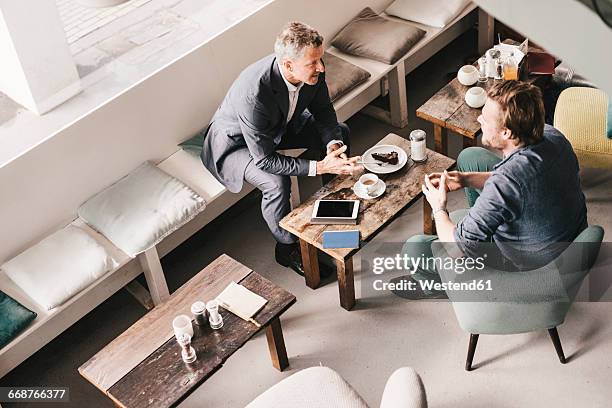 businessman consulting customer in cafe - two executive man coffee shop stock pictures, royalty-free photos & images