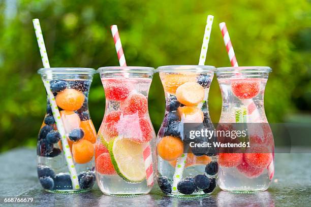 carafes of miscellaneous fruit infused water - infused water stockfoto's en -beelden