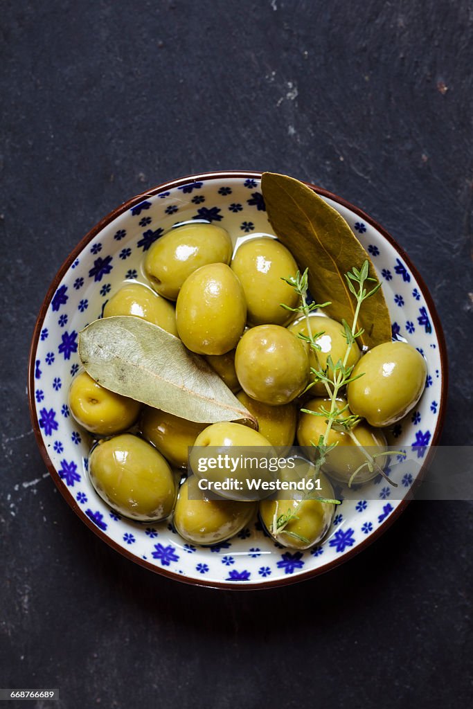 Green olives thyme and bay leaves in bowl