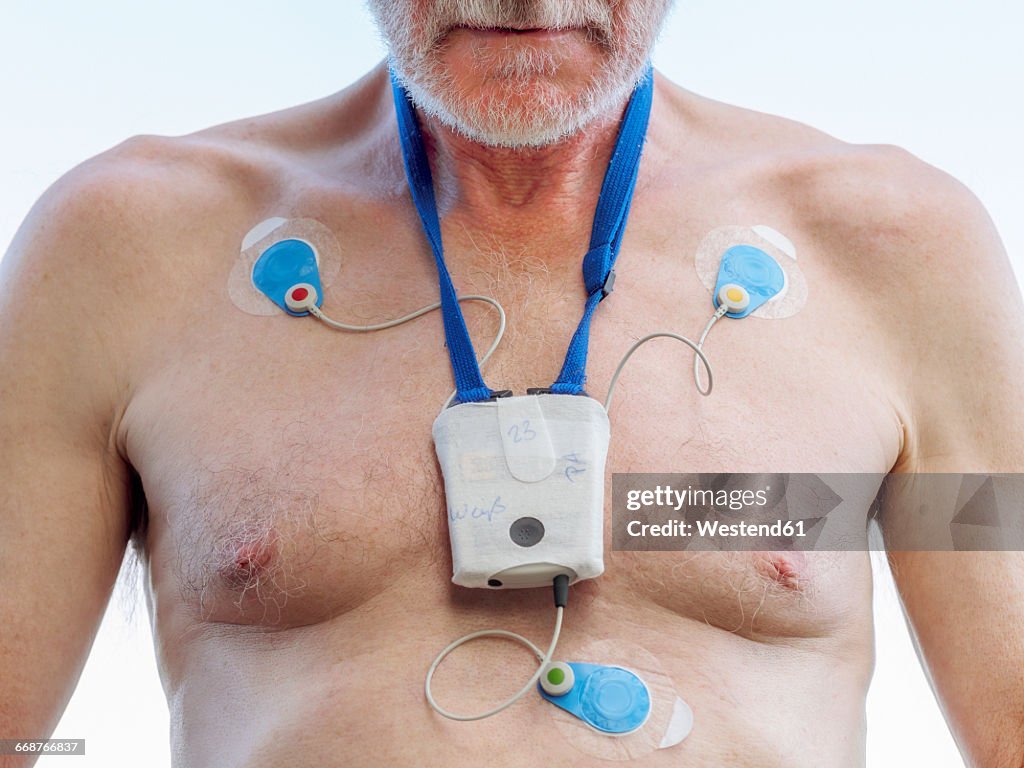 Senior man with long-term ECG on his chest, close up
