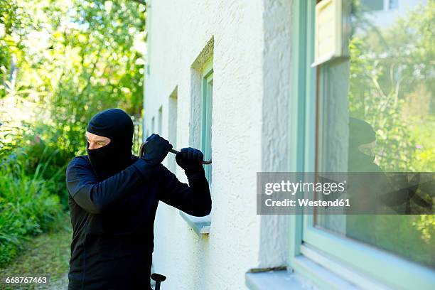 burglar with crowbar breaking window - cambrioleur photos et images de collection