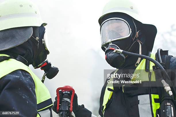 two firefighters wearing oxygen masks - feuerwehr deutschland stock-fotos und bilder