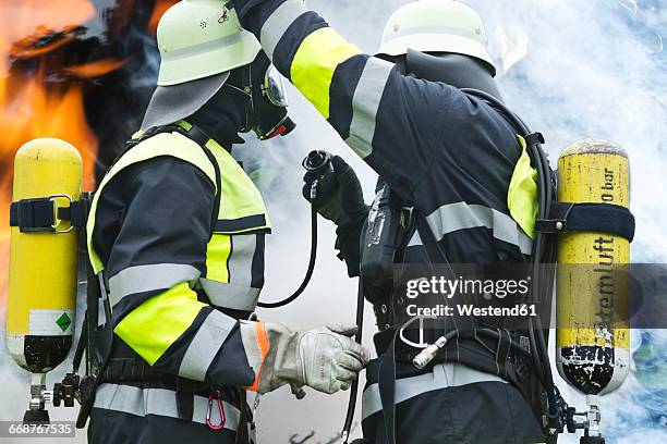 two firefighters preparing operation - feuerwehr deutschland stock-fotos und bilder