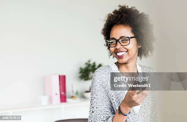 portrait of smiling businesswoman wearing glasses in office - joy business stock pictures, royalty-free photos & images