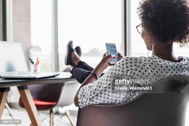 back view of woman text messaging - feet up stock pictures, royalty-free photos & images