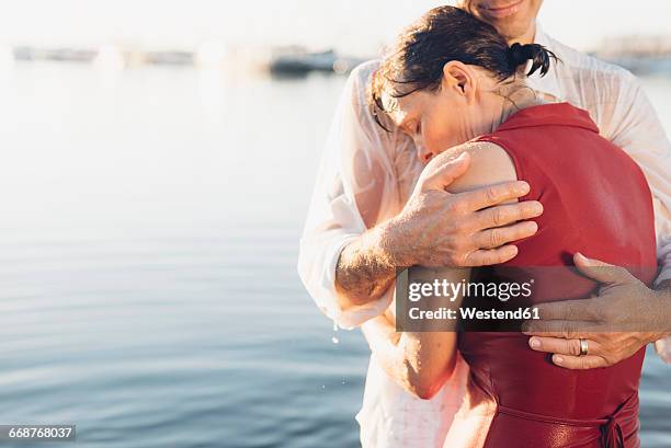 couple embracing at lake - 庇護者 ストックフォトと画像