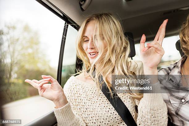 portrait of young woman with eyes closed listening music in a car - auto musik stock-fotos und bilder