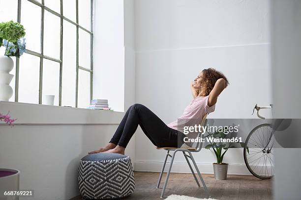 woman sitting in chair daydreaming - feet up stock pictures, royalty-free photos & images