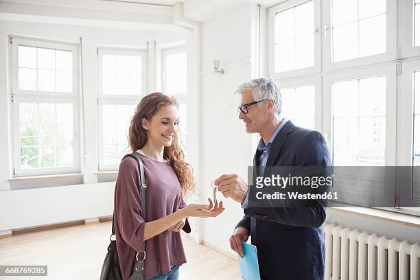 real estate agent handing over key to client - handing over keys stock pictures, royalty-free photos & images