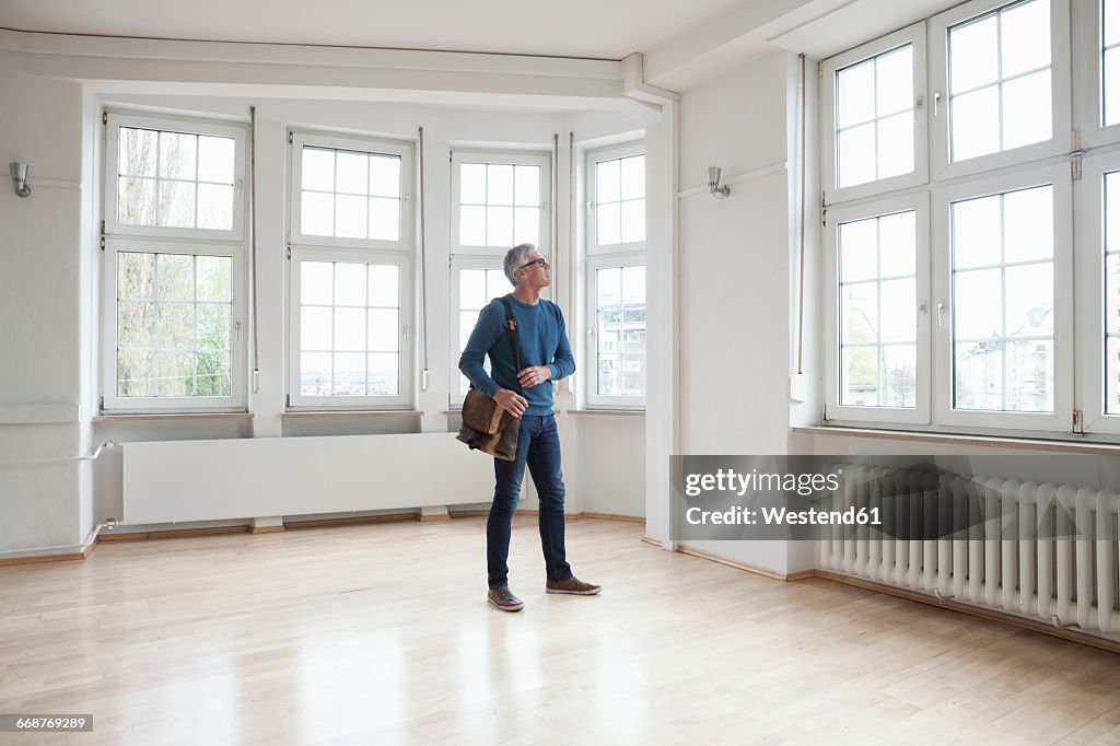 Man looking around in empty apartment