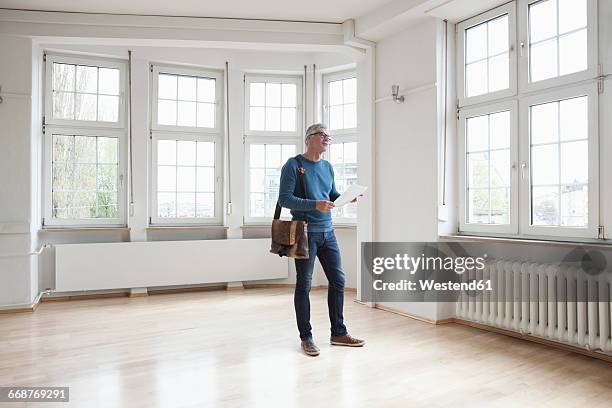 man looking around in empty apartment - flat inspection fotografías e imágenes de stock