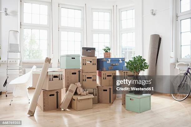 stack of cardboard boxes in empty apartment - move fotografías e imágenes de stock