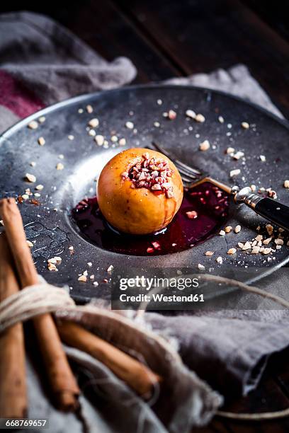 baked apple with nut- and red jam filling on tin plate - winter jam stock pictures, royalty-free photos & images